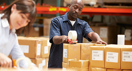 Employés emballant des cartons dans un entrepôt.