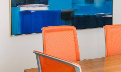 Chaises de bureau orange autour d'une table.